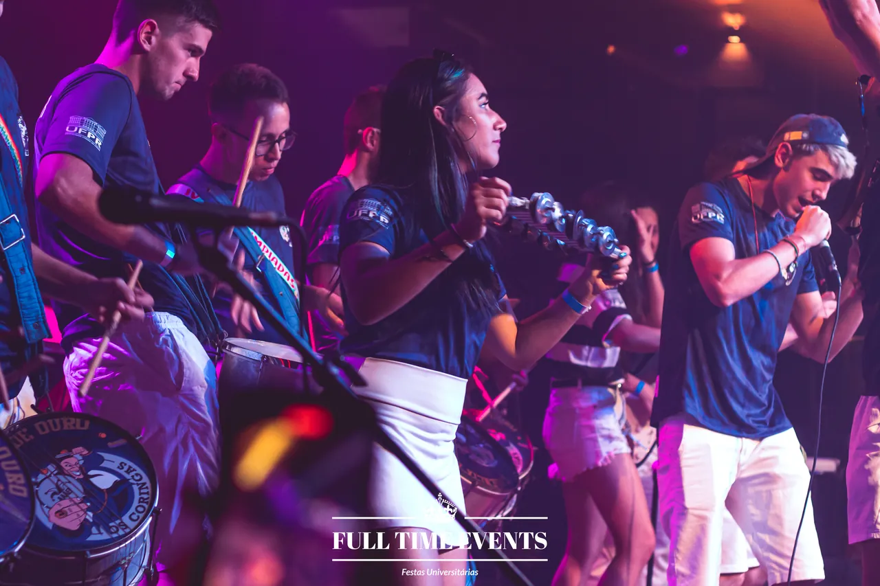 Bateria da atlética tocando no palco de festa universitária