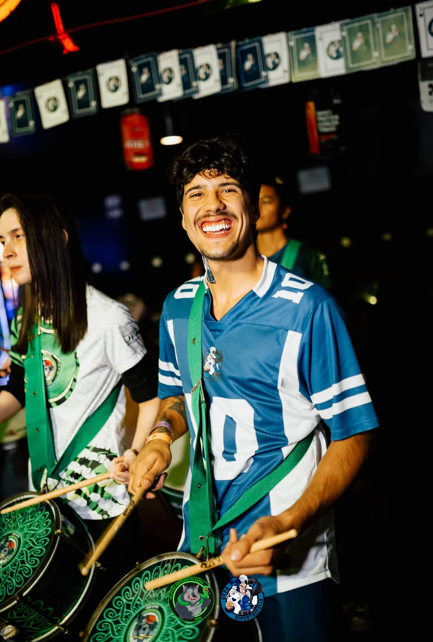 Ritmista da bateria da atlética sorrindo com o repique