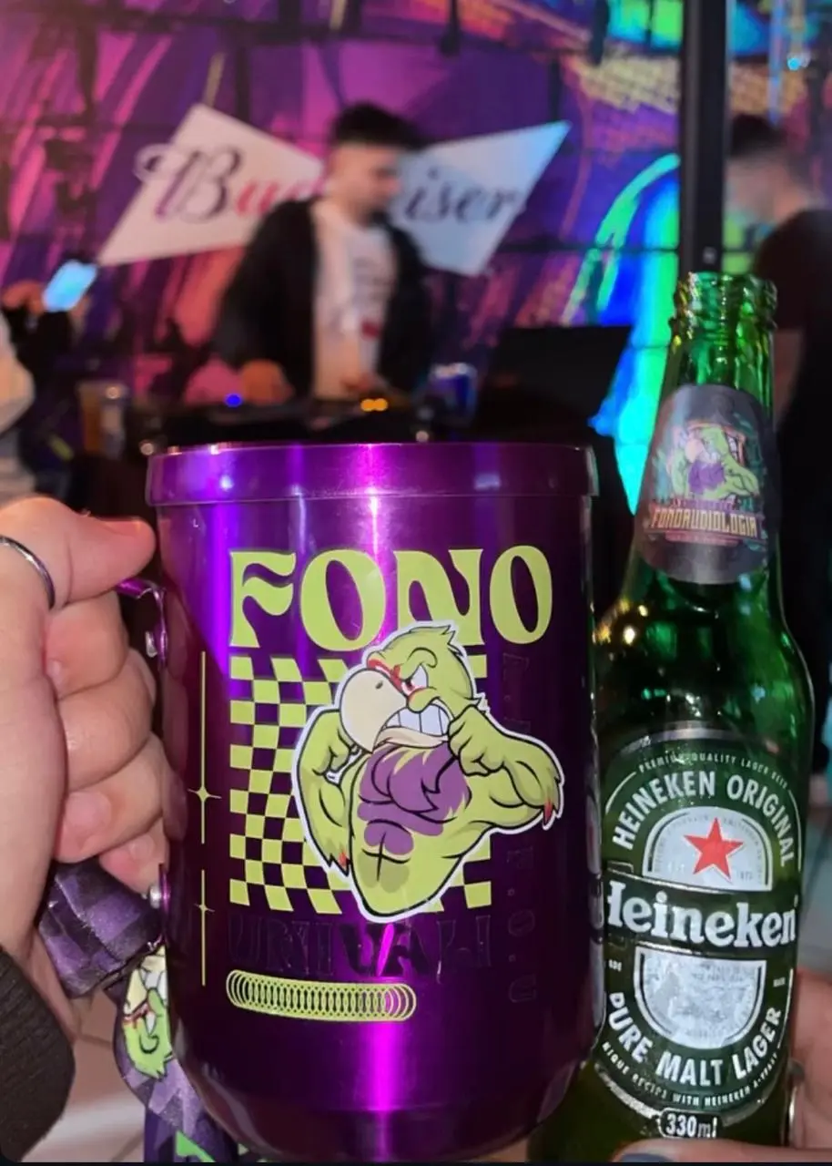 Copo personalizado da atlética levantado em festa universitária