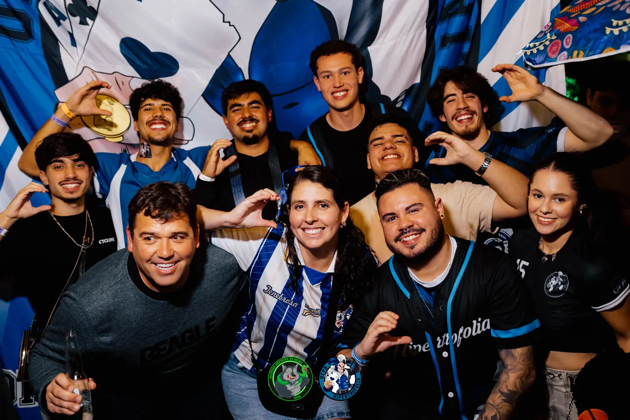 Galera da atlética posando diante da bandeira em festa