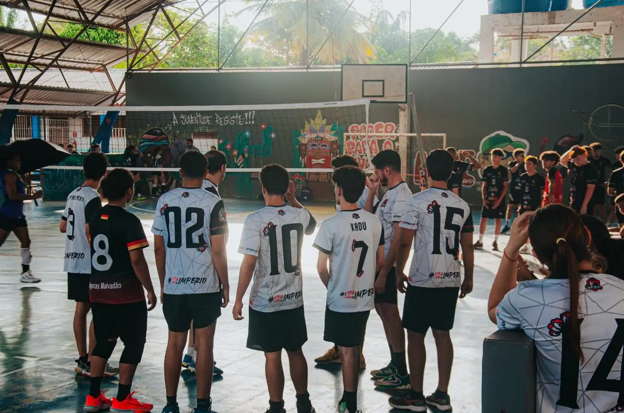 Time da atlética assistindo a partida de vôlei na quadra