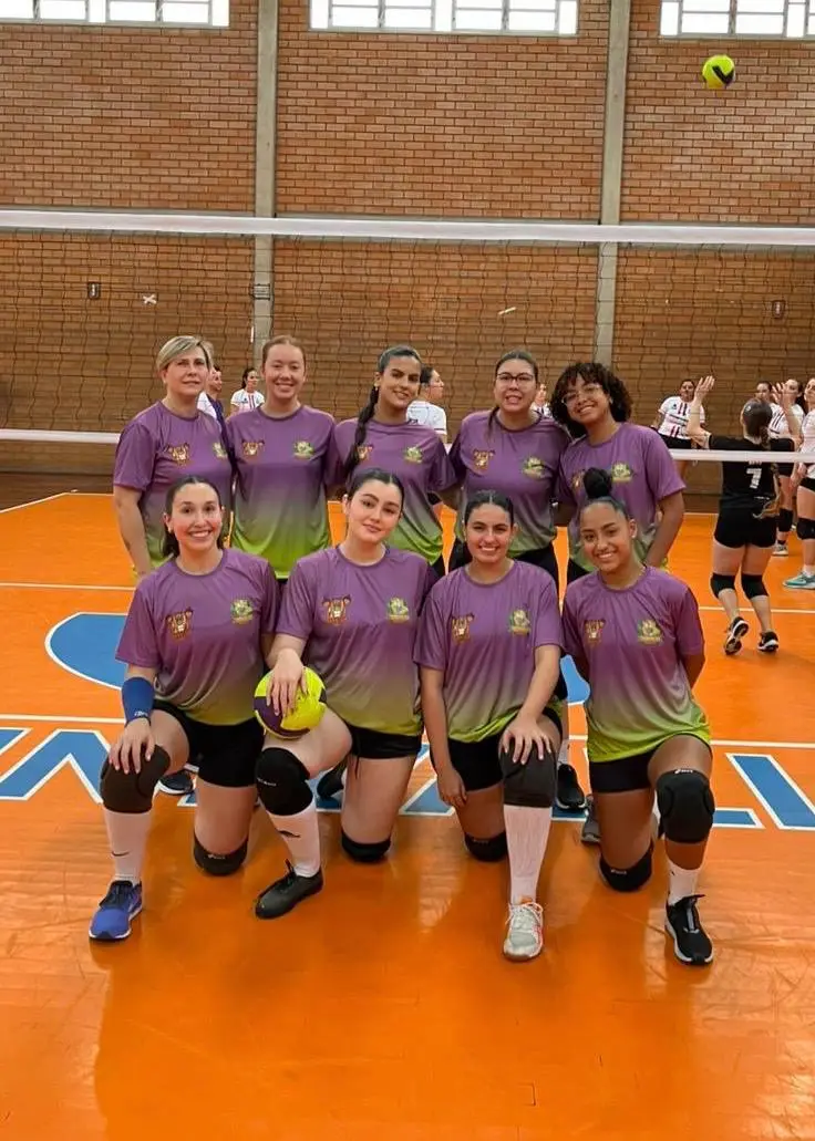 Time feminino de vôlei da atlética posando na quadra