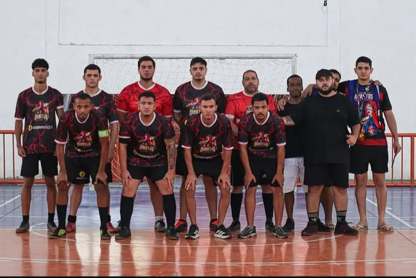 Time de futsal da atlética posando em frente ao gol na quadra